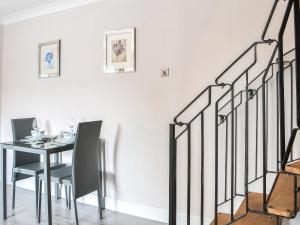 a dining room with a table and chairs and a staircase at Corner House in Sewerby