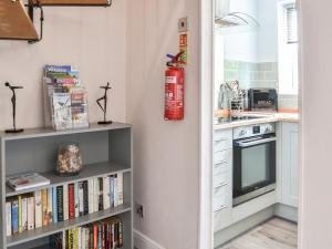 a kitchen with a book shelf filled with books at Corner House in Sewerby