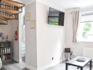 a living room with white walls and a table at Corner House in Sewerby