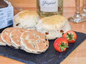 a group of buns and strawberries on a plate at Cartws Blaenparc Coach House - Uk41031 in Mydroilin