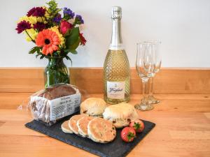 a table with a bottle of wine and a bunch of bread at Cartws Blaenparc Coach House - Uk41031 in Mydroilin