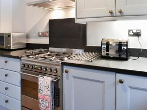 eine Küche mit einem Herd und einem Toaster in der Unterkunft Fairfield Cottage in Ambleside