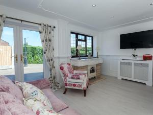 ein Wohnzimmer mit Sofa und Fernseher in der Unterkunft Buttercup Cottage in Halsall