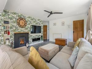 een woonkamer met een bank en een open haard bij By The Beach- Uk31201 in Downderry