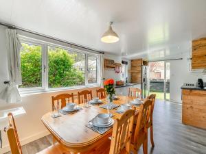 een keuken en eetkamer met een houten tafel en stoelen bij By The Beach- Uk31201 in Downderry