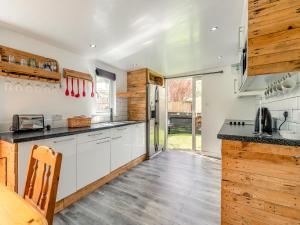 een keuken met witte kasten en een koelkast bij By The Beach- Uk31201 in Downderry +27 foto's