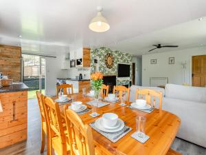 een eetkamer en een keuken met een houten tafel en stoelen bij By The Beach- Uk31201 in Downderry