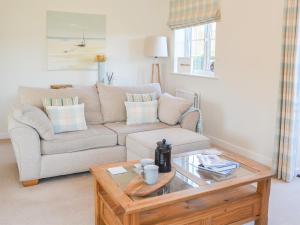 ein Wohnzimmer mit einer Couch und einem Couchtisch in der Unterkunft Good Tides in Beadnell