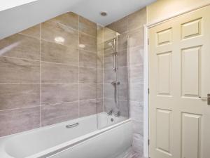 a bathroom with a white tub and a shower at 4 Dawson Court - Uk33414 in Mablethorpe +2 photos