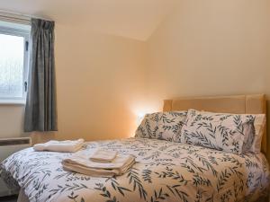 une chambre avec un lit avec des serviettes dessus dans l'établissement Swallowdale Cottage, à Levisham