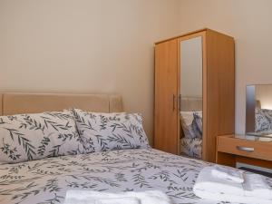 une chambre avec un lit et une armoire en bois dans l'établissement Swallowdale Cottage, à Levisham 8 autres photos