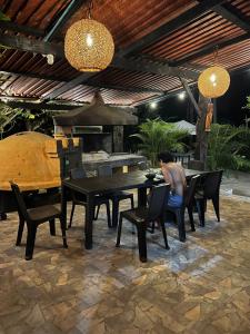 a man sitting at a table in a patio at Villa Camila in Trujillo