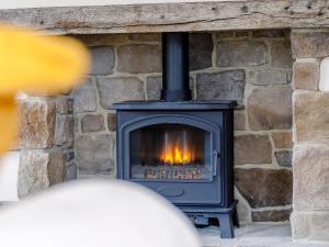 d'une cheminée en pierre avec une cheminée. dans l'établissement Cunliffe Cottage, à Hathersage