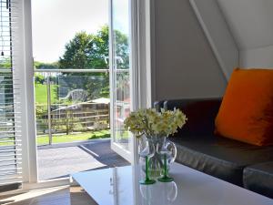 a living room with a couch and a table with flowers at Hives - W43108 in Bradworthy