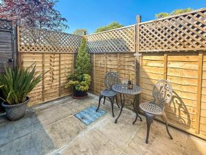 a patio with two chairs and a table and a fence at The Honeypot in Padstow +9 photos