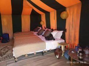 a bedroom with two beds in a tent at Merzouga Hous in Merzouga