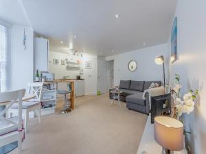 a living room with a couch and a kitchen at The Winch in Swanage