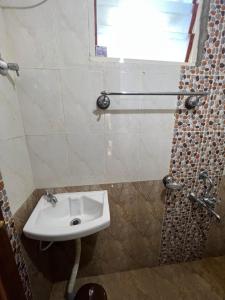 a bathroom with a white sink and a window at Coorg Mountain Breeze Homestay in Madikeri +2 photos