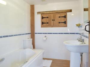 ein Badezimmer mit Badewanne, Waschbecken und Toilette in der Unterkunft Hayloft Cottage in Ludchurch