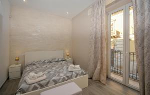 a bedroom with a bed and a large window at Stunning Home In Solarino in Solarino