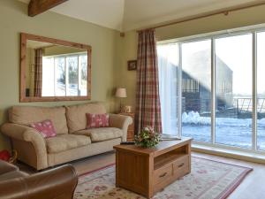 a living room with a couch and a large window at Calf House Cottage in Sedgefield