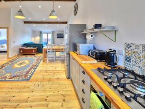 a kitchen with a stove top oven next to a living room at Rondo - Ukc3211 in Newbridge