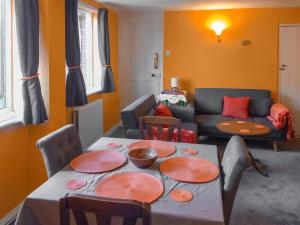 a living room with a table and a couch at 5 Rose Cottages in Sandhurst