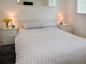 a bedroom with a bed with a striped comforter at Hives - W43108 in Bradworthy +9 photos