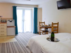 a room with a table with a bottle of wine on a bed at Lee Studio - Ukc3372 in West Down