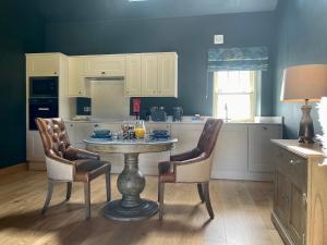 Una cocina con una mesa y dos sillas y una mesa. en The Granary - Uk40457, en Newsham