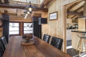 a dining room with a wooden table and chairs at Chalet le Findri in Le Fernuy