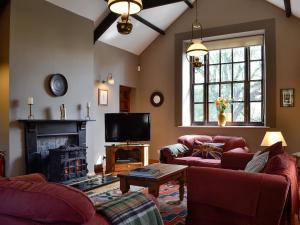 a living room with two couches and a tv at The Old School Penallt in Mitchel Troy