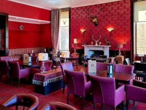 a restaurant with red walls and tables and chairs at Family Lodge No 2 The Place Downstairs - Uk45691 in Pitlochry