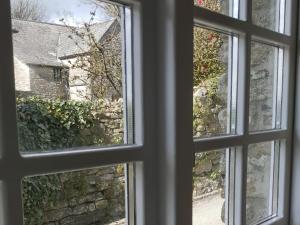an open window with a view of a building at Dovecote-Tnq in Camelford