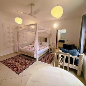 a bedroom with a canopy bed and a couch at Jumeirah Malindi Hotel in Malindi +36 photos