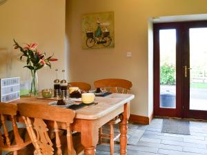 a dining room with a wooden table and chairs at Garden Cottage in Coldingham