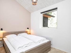 a bed in a white room with a window at 5 star holiday home in Millinge in Millinge