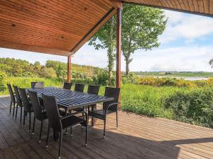 a dining table and chairs on a wooden deck at 5 star holiday home in Millinge in Millinge