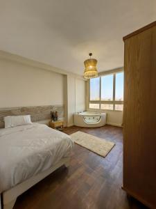 a bedroom with a bed and a tub and a window at Lamour GEM Pyramids View Hotel & Jacuzzi in Cairo