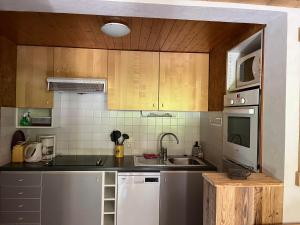 una cocina con fregadero y microondas en Vieille Bergerie 1, en Le Fernuy