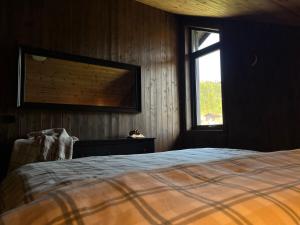 een slaapkamer met een bed en een kat op een tafel bij Modern and cozy mountain cabin - panoramic view! in Torvetjørn