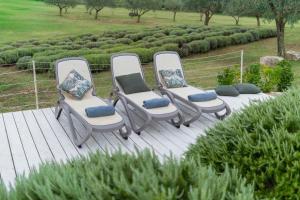 a group of three chairs sitting on a deck at Lavanda Apartments & Room in Sveti Lovreč Pazenatički