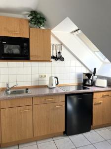 a kitchen with a sink and a black dishwasher at App 255Haus 6 in Dierhagen