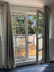 a sliding glass door to a balcony with a chair at App 255Haus 6 in Dierhagen +7 photos