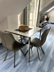a dining room table with two chairs and a bowl on it at App 255Haus 6 in Dierhagen