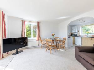 Great RyburghにあるBetty's Houseのテーブルとキッチンのあるリビングルーム