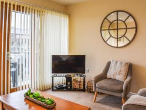 a living room with a television and a chair and a table at Swan House in Carnforth