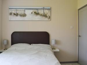 een slaapkamer met een bed met een foto van een strand bij 185 Golf Road in Mablethorpe