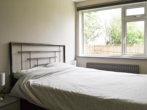 een slaapkamer met een groot wit bed met een raam bij 185 Golf Road in Mablethorpe