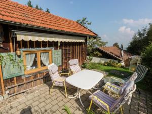 eine Terrasse mit Tisch und Stühlen vor einem Haus in der Unterkunft Idyllisches Ferienhaus mit Terrasse in Hohenpeißenberg